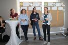 Vier Personen stehen vor einer Pinnwand