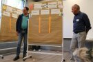 Zwei Männer stehen links und rechts von einer beschriebenen Pinnwand