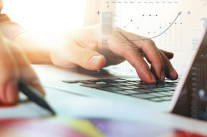 Hand gibt Daten aus einem Diagramm in Laptop ein  